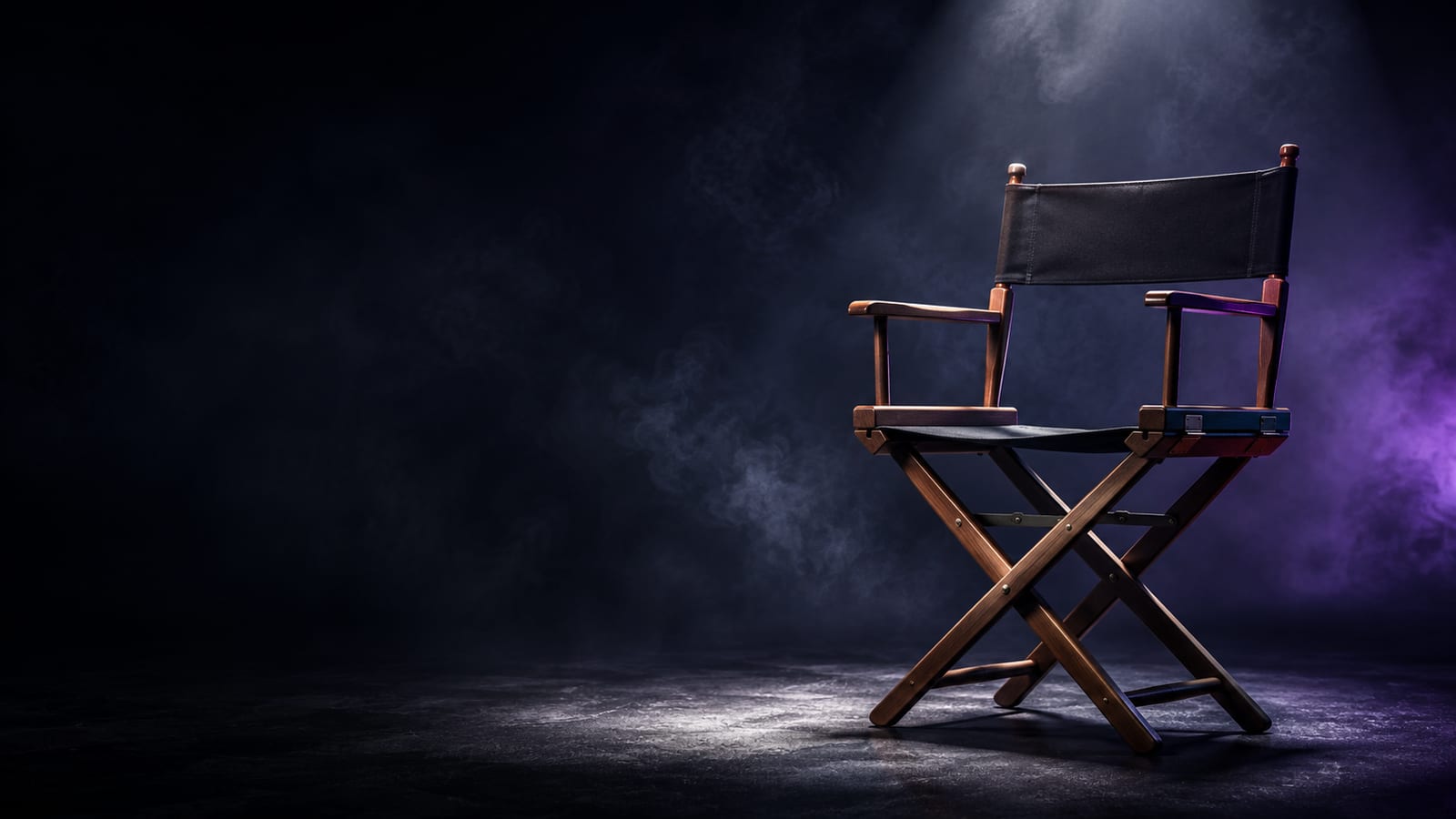 A director's chair lit in violet light with smoke on a dark sound stage